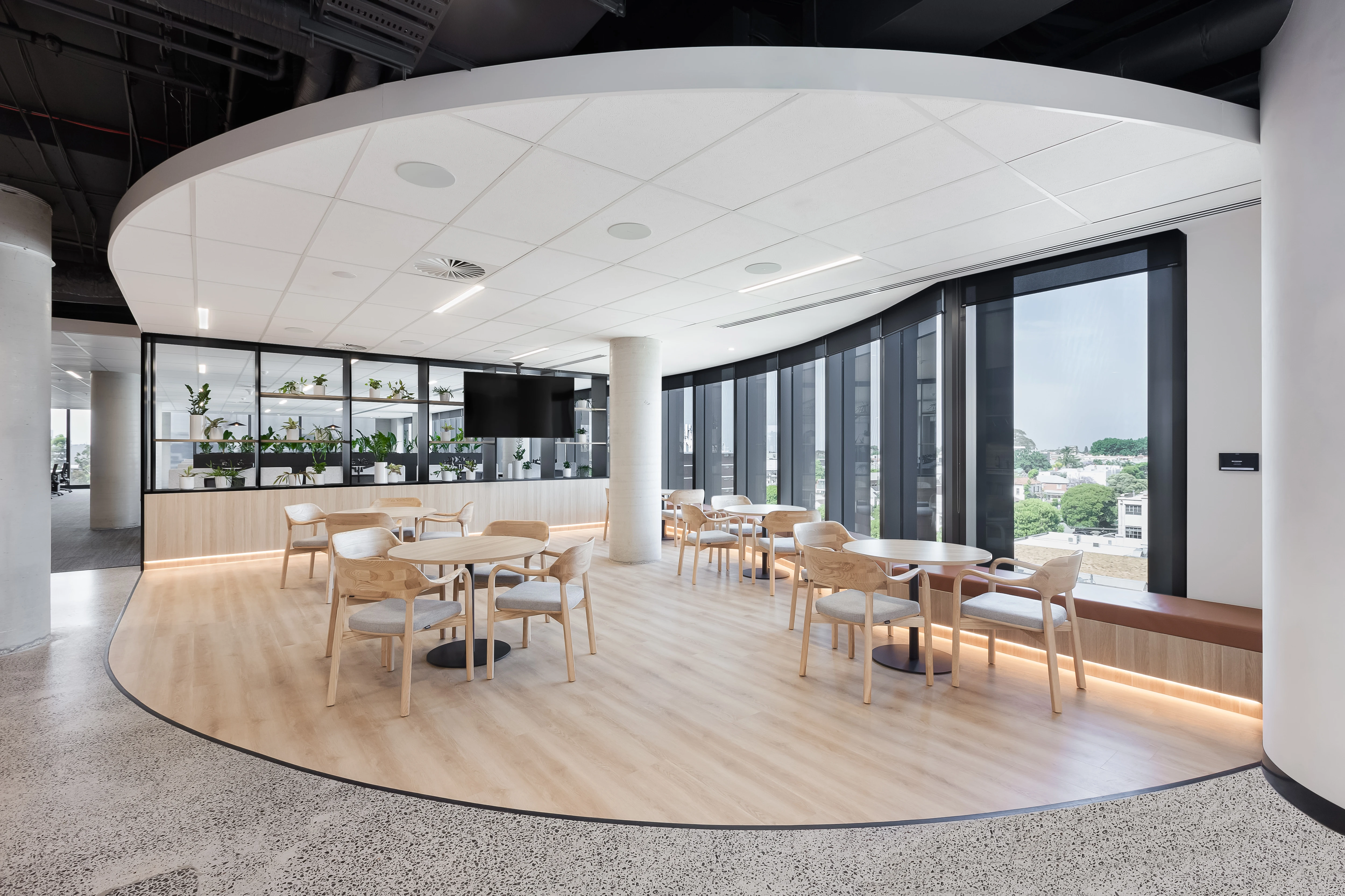 Lunchroom with circular Cosmopolitan tables, Taro chairs and built-in timber perimeter bench seating in natural light