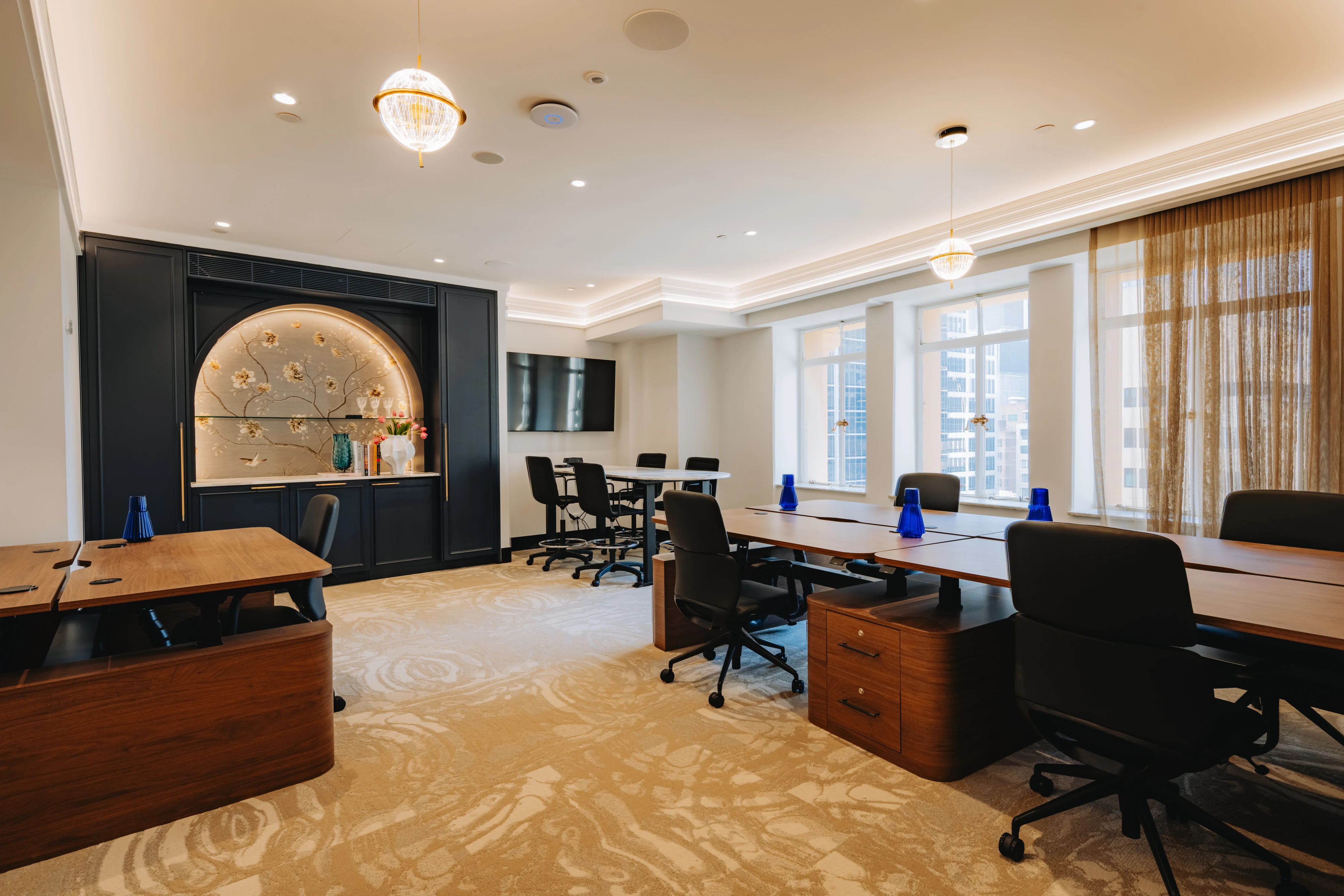Tajon private suite with a Swish height-adjustable workstation wrapped in bespoke curved casing and rounded timber pedestals