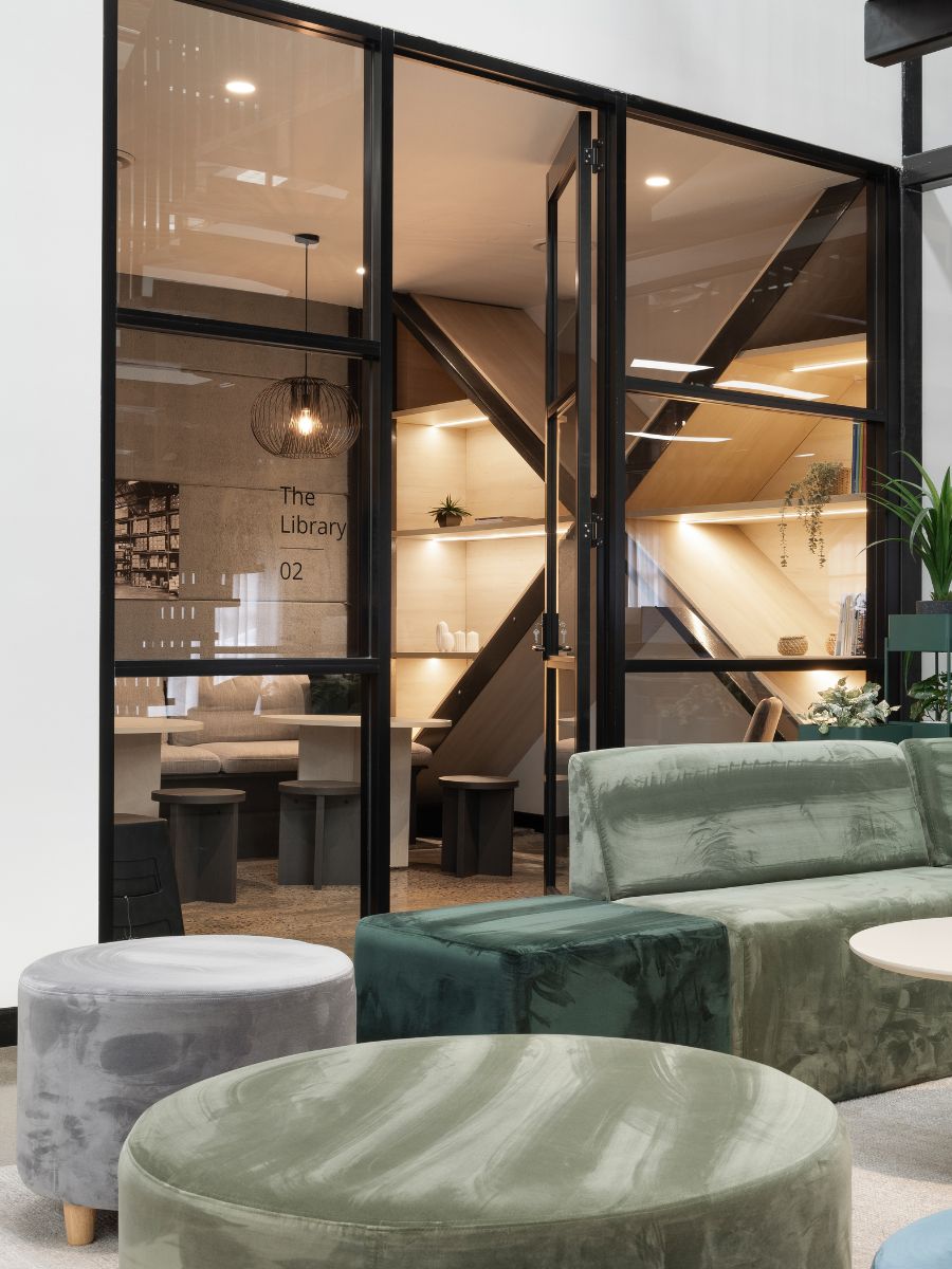 Fluted pedestal bar table and upholstered stools in front of the finishes wall in the Sydney showroom