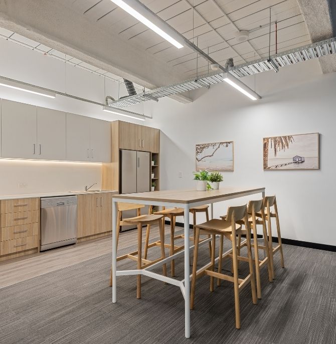 Kitchen with two-tone joinery, a Clic counter table and timber Ted stools