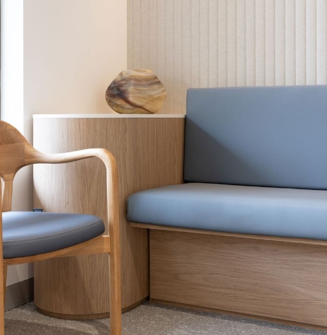 Classic banquette in soft blue fabric beside a Taro chair in natural ash